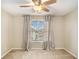 Carpeted bedroom features a ceiling fan, window, and gray curtains at 8000 Abington Dr, Locust Grove, GA 30248