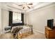 Cozy carpeted bedroom features a metal bed frame, ceiling fan, and modern light fixture at 8000 Abington Dr, Locust Grove, GA 30248