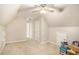 Neutral carpeted bonus room features vaulted ceilings, ceiling fan, and natural light at 8000 Abington Dr, Locust Grove, GA 30248