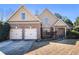 Beautiful two-story home with a brick facade, two-car garage, and a welcoming front entrance at 8000 Abington Dr, Locust Grove, GA 30248