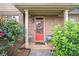 Charming front door with a red door, brick facade, and manicured landscaping at 8000 Abington Dr, Locust Grove, GA 30248