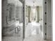 A modern bathroom featuring a glass shower, marble floors, tub, and stylish chandelier, filled with natural light at 581 Fairfield Nw Rd, Atlanta, GA 30327