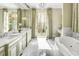 A light and bright bathroom featuring double vanities, marble floors, and French doors to a balcony at 581 Fairfield Nw Rd, Atlanta, GA 30327