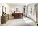 A cozy bedroom with a dark wooden bed frame, a dresser with a mirror and a window letting in natural light at 581 Fairfield Nw Rd, Atlanta, GA 30327