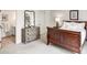 A bedroom with a wooden bed frame, a dresser with a mirror, and an adjoining bathroom at 581 Fairfield Nw Rd, Atlanta, GA 30327