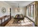 Elegant dining room with a large window, chandelier, and wood trim wall paneling at 581 Fairfield Nw Rd, Atlanta, GA 30327