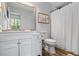 Bathroom with a white vanity, framed mirror, and shower/tub with white curtain at 9635 Loblolly Ln, Roswell, GA 30075