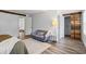 Tranquil bedroom with a sliding barn door, a gray loveseat, and access to other rooms at 9635 Loblolly Ln, Roswell, GA 30075