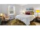 Bedroom features a comfortable bed, round rug, and a chair next to a bright window at 9635 Loblolly Ln, Roswell, GA 30075