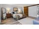 Spacious main bedroom with a rustic sliding barn door, warm lighting, and wood-look floors at 9635 Loblolly Ln, Roswell, GA 30075