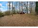 Charming light blue two-story home with a spacious, stained wooden deck, surrounded by lush, wooded landscaping at 9635 Loblolly Ln, Roswell, GA 30075