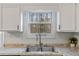 Clean kitchen featuring a stainless steel sink, light countertops, and ample cabinet space at 9635 Loblolly Ln, Roswell, GA 30075