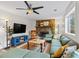 Cozy living room showcasing a stone fireplace, large television, and comfortable green sectional at 9635 Loblolly Ln, Roswell, GA 30075