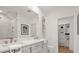 Bright bathroom featuring double vanity, large mirror, and a view into a closet for optimal convenience at 201 New St # 2207-1, Decatur, GA 30030