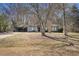 Wide shot of the home featuring a grey exterior, a covered parking area, and a generous front yard at 3759 Rosemary Se Ln, Conyers, GA 30013