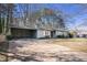 View of the home's exterior featuring a large driveway and a convenient carport area at 3759 Rosemary Se Ln, Conyers, GA 30013