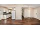 Open-concept living room featuring wood floors that flow into a kitchen with white cabinets and appliances at 3759 Rosemary Se Ln, Conyers, GA 30013