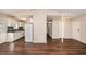 Spacious room with hardwood floors connecting to a kitchen with white appliances and cabinetry at 3759 Rosemary Se Ln, Conyers, GA 30013