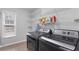 Well-organized laundry room features modern washer and dryer units, ample shelving, and natural light from a window at 4178 Glenaire Nw Way, Acworth, GA 30101