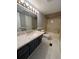Well-lit bathroom featuring a spacious vanity with a large mirror and updated fixtures, plus a shower/tub combo at 5559 John Burruss Rd, Cumming, GA 30040