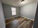 Cozy bedroom with neutral walls, wood-look flooring, and a well-lit window for a serene atmosphere at 5559 John Burruss Rd, Cumming, GA 30040