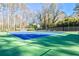 Well-maintained community tennis courts with vibrant blue and green surfaces, surrounded by tall trees and fencing at 1830 Greystone Ct, Marietta, GA 30068