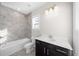 Bright bathroom featuring a bathtub, single sink vanity, and a window with natural light at 2028 Holtz Ln, Atlanta, GA 30318