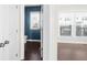 Hallway view into a half bathroom with a blue accent wall, window and white fixtures in the home at 2028 Holtz Ln, Atlanta, GA 30318