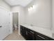 A modern bathroom featuring dark cabinetry, quartz countertop, and tile flooring at 2028 Holtz Ln, Atlanta, GA 30318