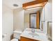 Bathroom features a white toilet, sink with mirror and wooden accents at 566 Hickory Hills Ct, Stone Mountain, GA 30083