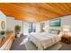 Staged main bedroom with white bed, wood ceiling, and an adjacent outdoor deck at 566 Hickory Hills Ct, Stone Mountain, GA 30083