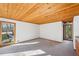 Unstaged bedroom featuring natural light from windows and door to the backyard, plus wooden ceiling at 566 Hickory Hills Ct, Stone Mountain, GA 30083