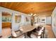 Open-concept dining room with wood plank ceiling and decorative light fixture at 566 Hickory Hills Ct, Stone Mountain, GA 30083