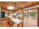 Bright kitchen features wooden cabinets, stainless steel stove and oven, and adjacent bright sunroom with windows at 566 Hickory Hills Ct, Stone Mountain, GA 30083