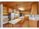 Open concept kitchen with stainless steel refrigerator, wooden cabinets, and attached island with seating at 566 Hickory Hills Ct, Stone Mountain, GA 30083