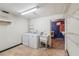 Functional laundry room with washer, dryer, utility sink, and access to the basement at 566 Hickory Hills Ct, Stone Mountain, GA 30083