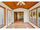 Bright sunroom with floor to ceiling windows, with view to kitchen with stainless steel appliances and wooden cabinets at 566 Hickory Hills Ct, Stone Mountain, GA 30083