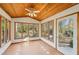 Sunroom featuring wooden ceiling, tile floors, surrounded by many large windows, and a door to the backyard at 566 Hickory Hills Ct, Stone Mountain, GA 30083