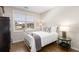 Bright bedroom featuring a wrought iron bed frame, hardwood floors, and a large window at 108 Brighton Blvd, Woodstock, GA 30188