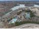 Aerial view showing community tennis courts, pool, lake, and clubhouse amid lush greenery at 214 White Cloud Run, Canton, GA 30114