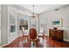 Sunlit dining area featuring wood floors, elegant chandelier, and large windows with natural light at 214 White Cloud Run, Canton, GA 30114