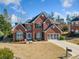 Charming brick home with a well-manicured lawn, two-car garage, and classic architectural details at 214 White Cloud Run, Canton, GA 30114