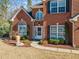 Elegant brick home featuring arched windows, a well-kept lawn, and manicured landscaping enhancing curb appeal at 214 White Cloud Run, Canton, GA 30114