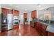 Large kitchen showcasing stainless steel appliances, hardwood floors, and seamlessly connecting to the living room at 214 White Cloud Run, Canton, GA 30114