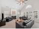 Bright living room features a fireplace, ceiling fan, and multiple large windows for natural light at 214 White Cloud Run, Canton, GA 30114