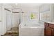 Another view of primary bathroom featuring tub and shower, plus a double window for natural light at 214 White Cloud Run, Canton, GA 30114