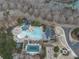 Aerial view of the community pool with a slide, splash pad, and lap pool surrounded by mature trees at 214 White Cloud Run, Canton, GA 30114