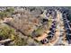 An aerial shot showcases a vast wooded lot with a home, surrounded by a well-established neighborhood at 2499 E Maddox Rd, Buford, GA 30519