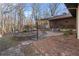 Backyard view highlighting a stone patio area with outdoor seating and manicured landscaping at 2499 E Maddox Rd, Buford, GA 30519