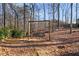 Backyard view featuring a lovely swing suspended between mature trees and a rustic seat at 2499 E Maddox Rd, Buford, GA 30519